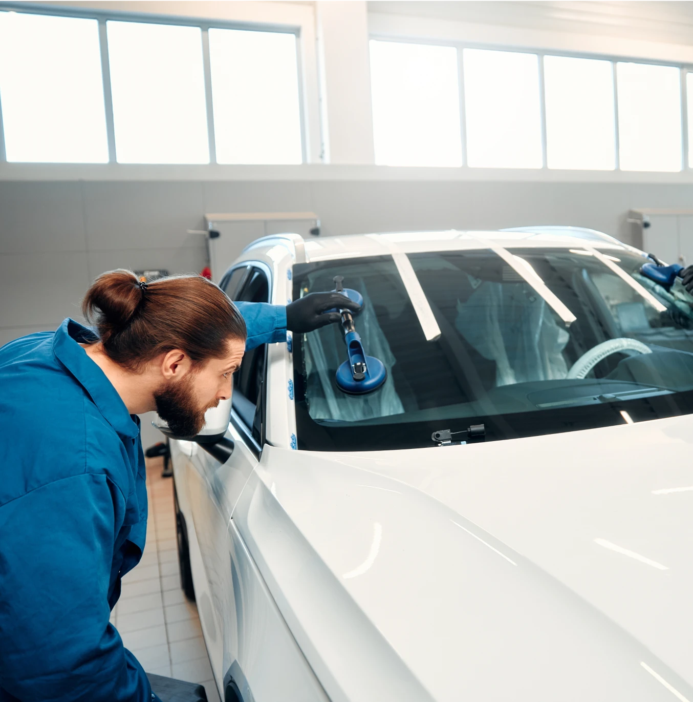 Auto technician checking windshield repair